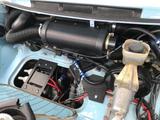 a Porsche 911 smugglers box containing an electric air conditioning compressor  next to a HVAC blower unit in light blue Porsche 911