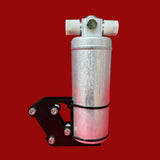 Metal component on a red surface with a blurred workshop background