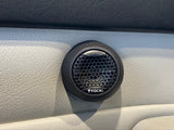 A black car speaker on a grey leather door interior panel