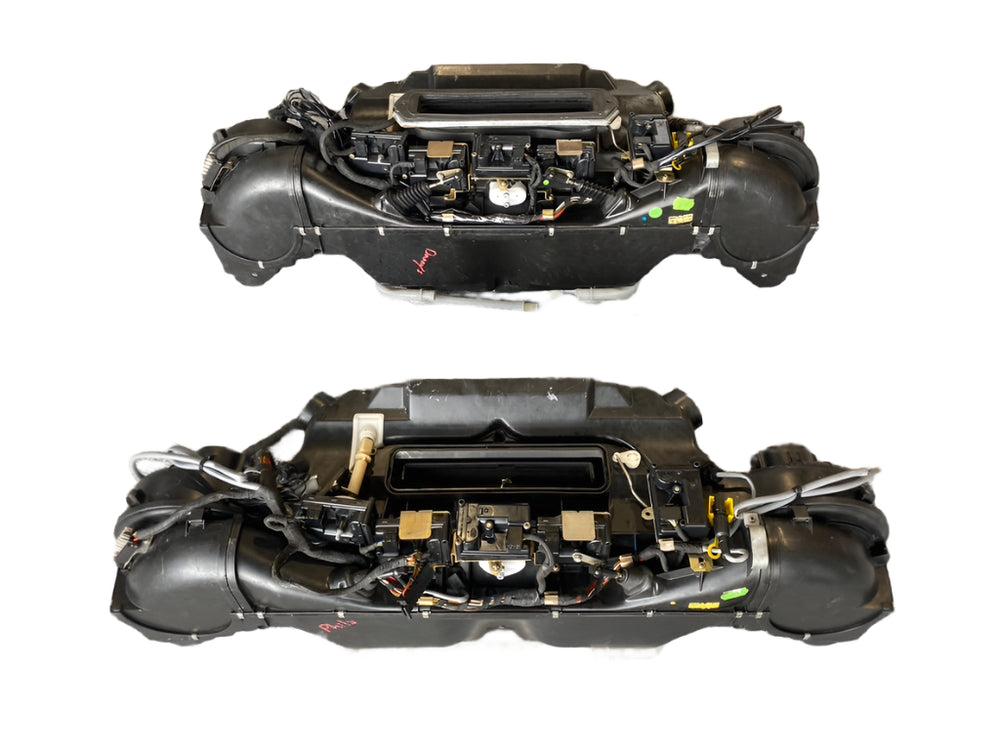 Two Porsche 993 and 964 air conditioning and heating blower units on a white background
